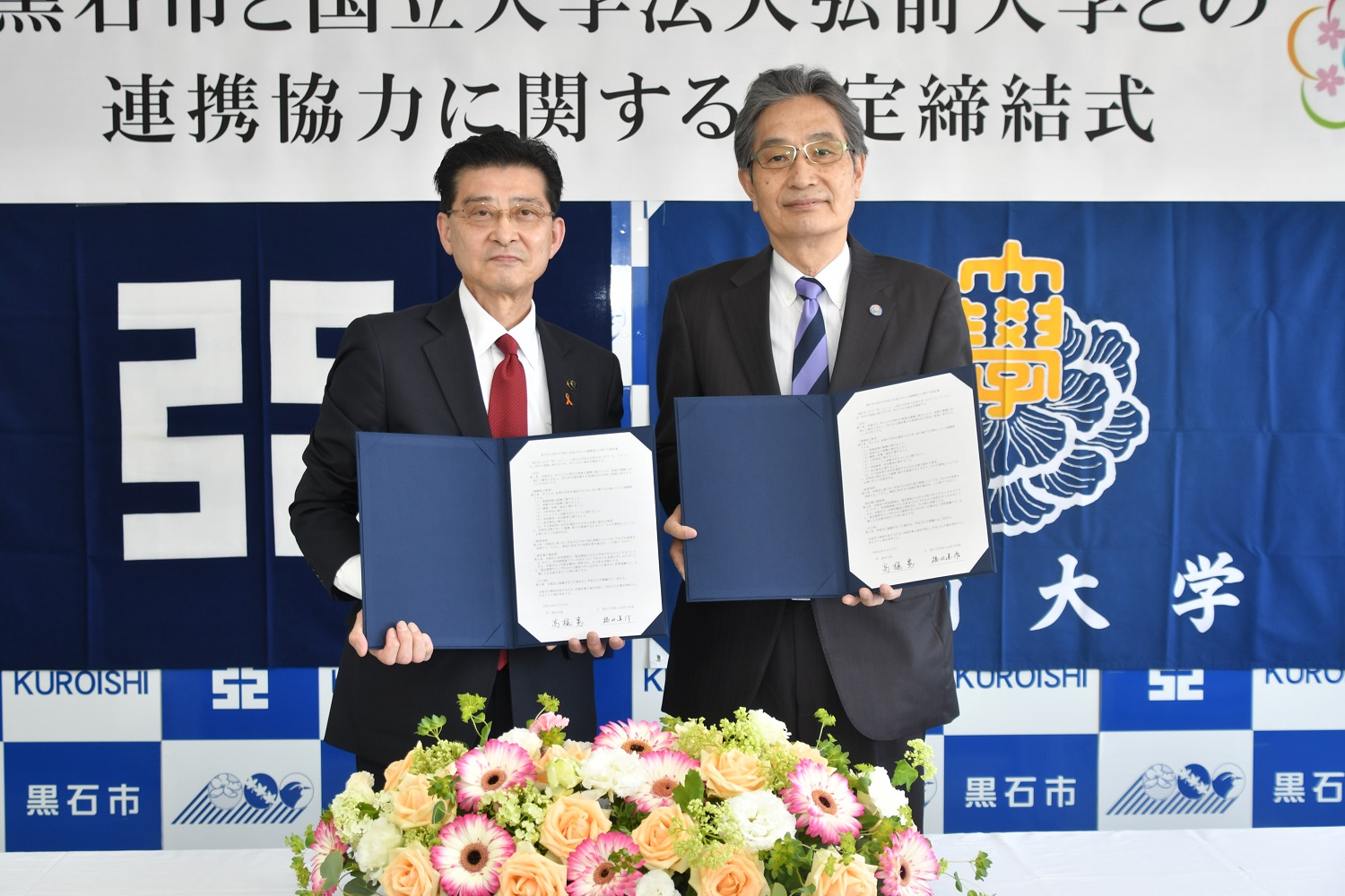 協定書を手にする高樋市長（左）と福田学長（右） 